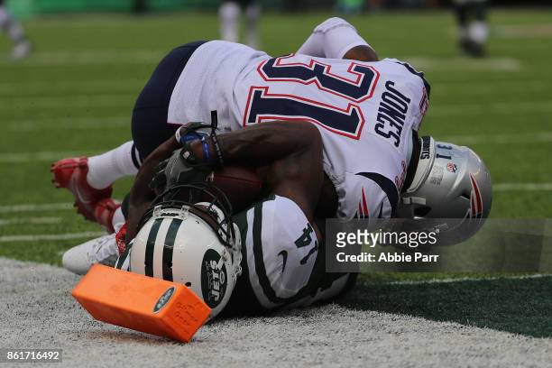 Cornerback Jonathan Jones of the New England Patriots tackles wide receiver Jeremy Kerley of the New York Jets during the second quarter of their...