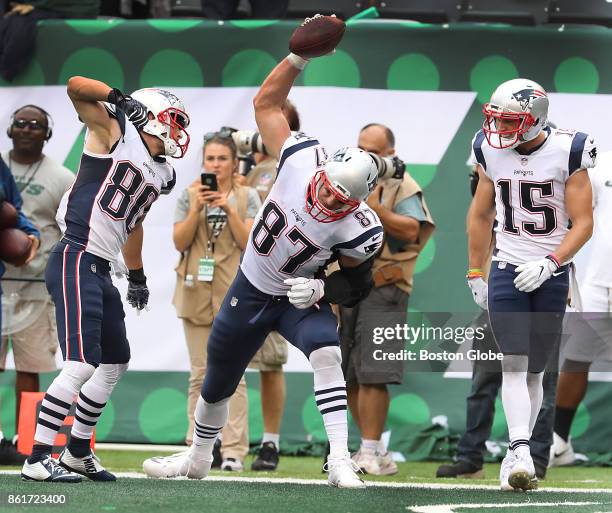 New England Patriots' Rob Gronkowski spikes the ball after a touchdown reception with approval from teammates Danny Amendola, left, and Chris Hogan...