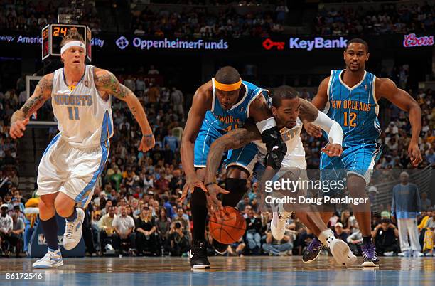 James Posey of the New Orleans Hornets and J.R. Smith of the Denver Nuggets battle for a loose ball as Chris Andersen of the Nuggets and Hilton...