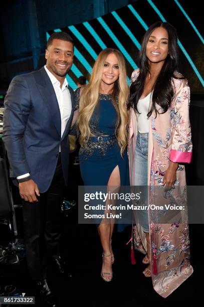 In this handout photo provided by One Voice: Somos Live!, NFL player Russell Wilson and singers Jennifer Lopez and Ciara pose backstage during "One...