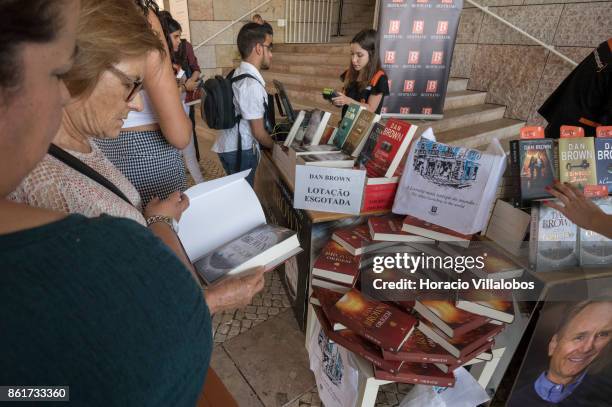 Customers browse a copy of the Portuguese edition of "Origin", Dan Brown last book, at Bertrand Editora stand before attending its presentation by...