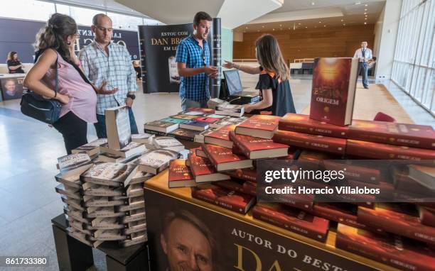 Customers buy copies of the Portuguese edition of "Origin", Dan Brown last book, at Bertrand Editora stand before attending its presentation by the...