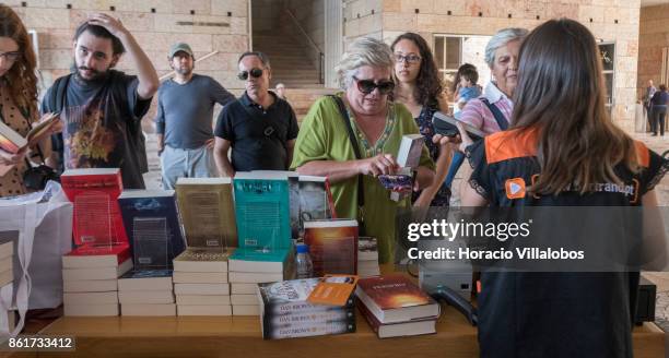 Customers buy copies of the Portuguese edition of "Origin", Dan Brown last book, at Bertrand Editora stand before attending its presentation by the...