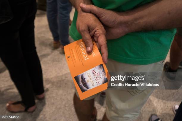 Man holds his invitation while waiting to attend the presentation of the Portuguese edition of "Origin", Dan Brown last book, by the author at Centro...