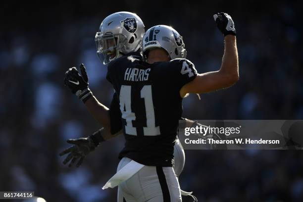 Keith McGill and Erik Harris of the Oakland Raiders react after a play against the Los Angeles Chargers during their NFL game at Oakland-Alameda...