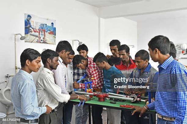 Students gather around a table during a plumbing class at an IACM Smart Learn Ltd. Learning center in New Delhi, India, on Tuesday, Oct. 10, 2017. By...