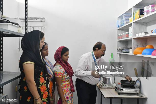 Students gather around a cooking stove during a house-keeping class at an IACM Smart Learn Ltd. Learning center in New Delhi, India, on Tuesday, Oct....