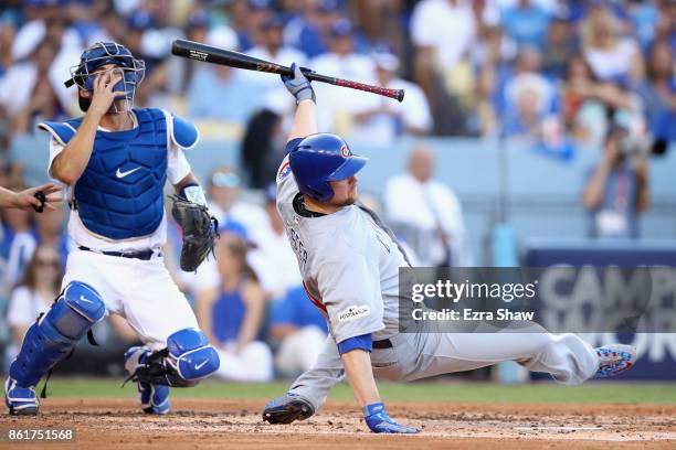 Jon Lester of the Chicago Cubs falls to the ground after a wild pitch in the third inning during Game Two of the National League Championship Series...