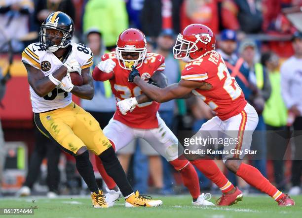 Pittsburgh Steelers wide receiver Antonio Brown pulls away from Kansas City Chiefs cornerback Jacoby Glenn and cornerback Marcus Peters for a first...