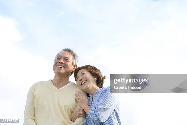 mature woman embracing man, smiling - older asian couple stock pictures, royalty-free photos & images