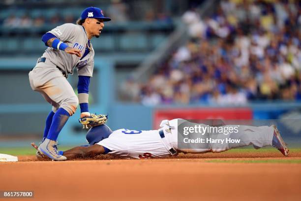 Javier Baez of the Chicago Cubs tags out Yasiel Puig of the Los Angeles Dodgers as he attempts to steal second base in the fourth inning during game...