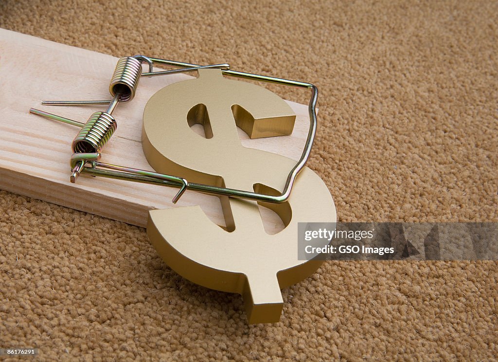 US Dollar symbol caught in a mousetrap