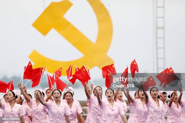 This photo taken on October 13, 2017 shows people performing to welcome the upcoming 19th Party Congress in Huaibei in China's eastern Anhui...