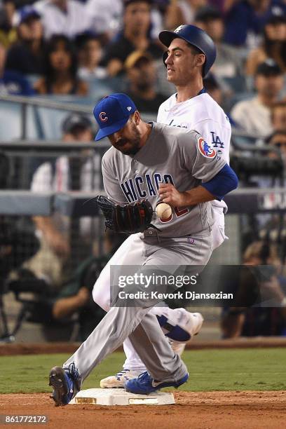 Brian Duensing of the Chicago Cubs drops the throw to first base as Cody Bellinger of the Los Angeles Dodgers is safe after hitting a single in the...