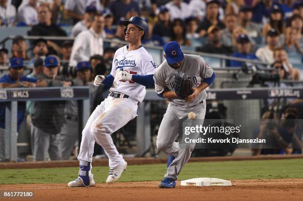 Brian Duensing of the Chicago Cubs drops the throw to first base as Cody Bellinger of the Los Angeles Dodgers is safe after hitting a single in the...