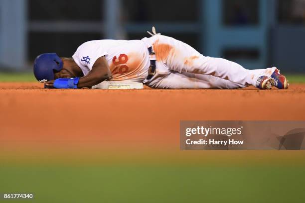 Yasiel Puig of the Los Angeles Dodgers lies on the ground after reaching second base on a sacrifice bunt in the ninth inning against the Chicago Cubs...