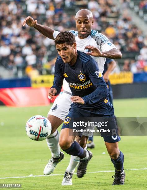 Jonathan dos Santos of Los Angeles Galaxy battles Collen Warner of Minnesota United during the Los Angeles Galaxy's MLS match against Minnesota...