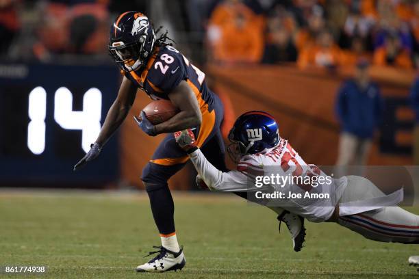 Darian Thompson of the New York Giants stretches to wrap up Jamaal Charles of the Denver Broncos during the third quarter of the on Sunday, October...