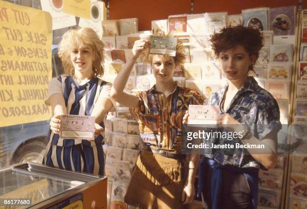 Portrait of the members of pop group Banarama as the pose in a shop, each holding a card with an astrological symbol, London, England, 1981. Pictured...