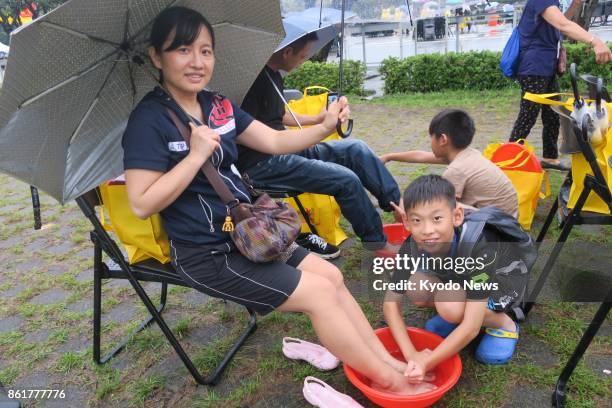 Ko Guan-yu, a fourth-grader, washes the feet of his mother at a mass foot-washing ceremony in front of the Presidential Office on Oct. 15, 2017....
