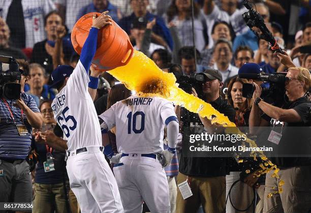 Kyle Farmer of the Los Angeles Dodgers dunks Justin Turner with Gatorade after Turner hit a three-run walk-off home run in the ninth inning to defeat...