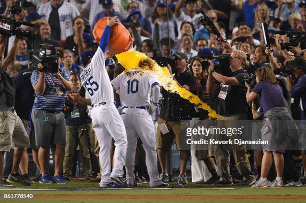 Kyle Farmer of the Los Angeles Dodgers dunks Justin Turner with Gatorade after Turner hit a three-run walk-off home run in the ninth inning to defeat...