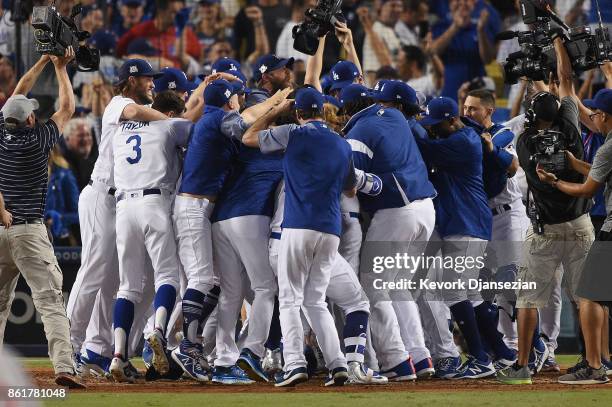 Justin Turner of the Los Angeles Dodgers celebrates with teammates after hitting a three-run walk-off home run in the ninth inning to defeat the...