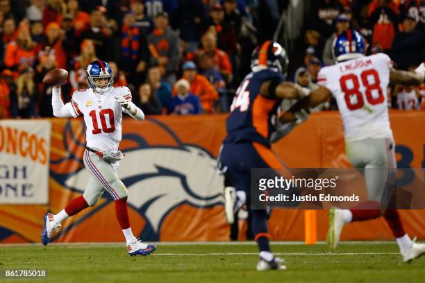 Quarterback Eli Manning of the New York Giants throws a pass on the run as Evan Engram tries to get open while being defended by Inside Linebacker...