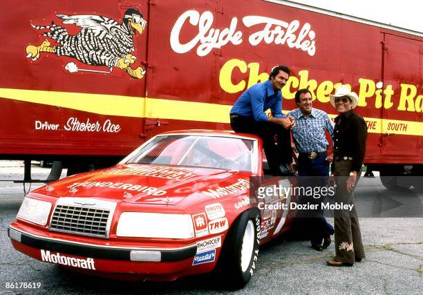 Actor Burt Reynolds poses with Jim Nabors and Hal Needham during the filming of a racing movie, Stroker Ace, in August, 1982 at the Lakewood Park...