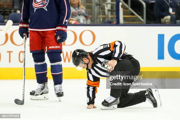 Referee Kyle Rehman fixes a spot on the ice during the first period in a game between the Columbus Blue Jackets and the New York Rangers on October...