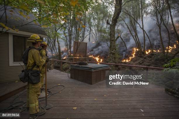 Firefighters keep watch over a backfire set to protect houses in Adobe Canyon during the Nuns Fire on October 15, 2017 near Santa Rosa, California....