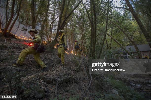 Firefighters set a backfire to protect houses in Adobe Canyon during the Nuns Fire on October 15, 2017 near Santa Rosa, California. At least 40...