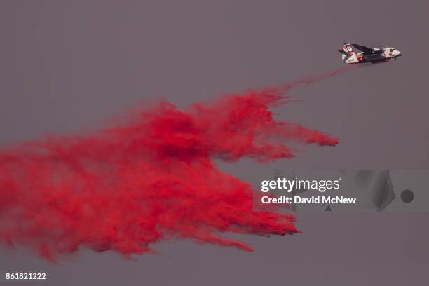 Cal Fire Air Tanker 89 drops fire retardant during the Oakmont Fire on October 15, 2017 near Santa Rosa, California. At least 40 people were killed...