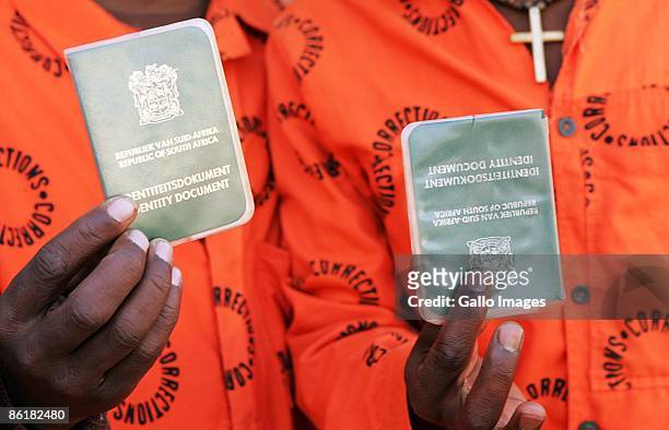 Prisoners show their ID books before they cast their votes, on April 22, 2009 in Bloemfontein, South Africa. The ruling African National Congress was...