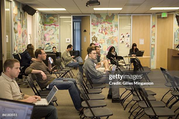 Young employees gather in the meeting room at the Facebook headquarters to learn about 401K pension plans, and every Friday to hear updates and ask...