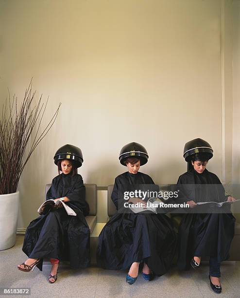 ladies at salon under hair dryers reading magazine - beauty salon stock pictures, royalty-free photos & images