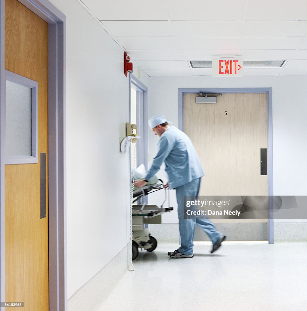 Anesthesiologist wheeling patient into surgery