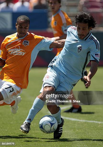 Bobby Boswell of the Houston Dynamo dribbles the ball away from Pablo Mastroeni of the Colorado Rapids at Robertson Stadium on April 19, 2009 in...