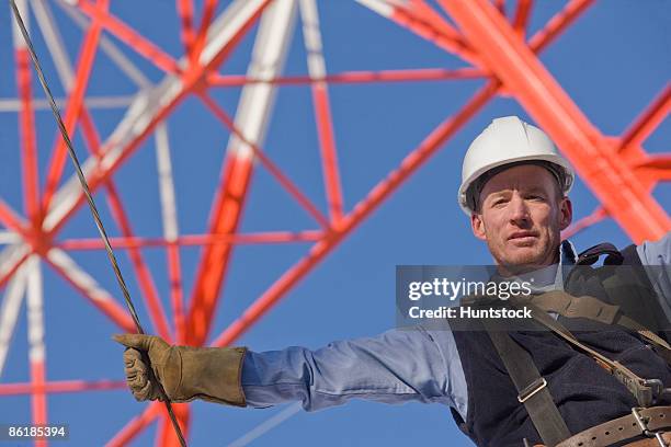 low angle view of a cable lineman - torre di trasmissione a microonde foto e immagini stock