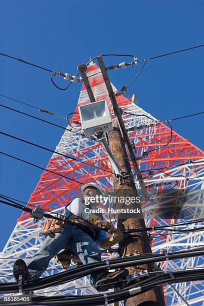 cable lineman repairing transmission line - tour de transmission par micro ondes photos et images de collection