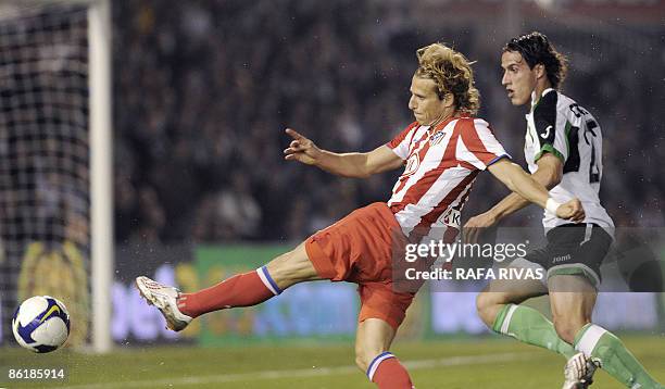 Atletico Madrid's Diego Forlan shoots next to Racing Santander´s Christian Fernandez during a Spanish league football match, on April 23 at Sardinero...