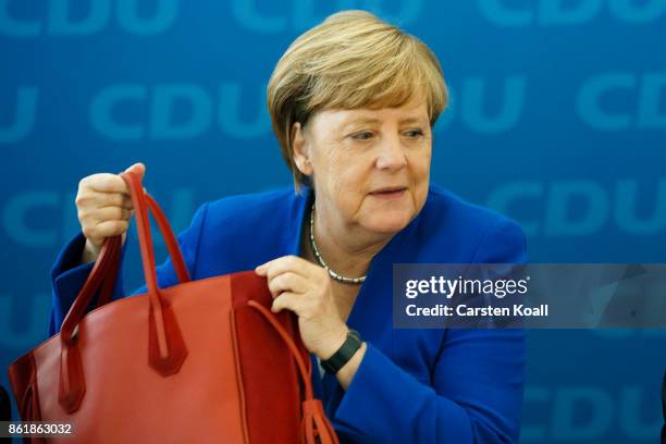 German Chancellor and leader of the German Christian Democrats Angela Merkel holds her bag at a meeting of the CDU board on October 16, 2017 in...