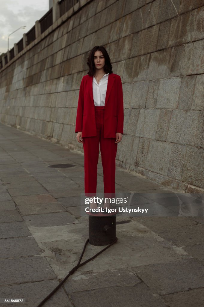 Woman in red pantsuit walking in the city