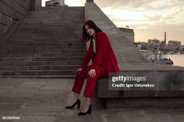 woman in red pantsuit  walking in the city - pant suit fotografías e imágenes de stock