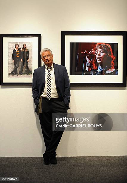 French photographer Jean-Marie Perier poses between pictures of Rolling Stones' Mick Jagger posing with French singer Francoise Hardy and Mick Jagger...