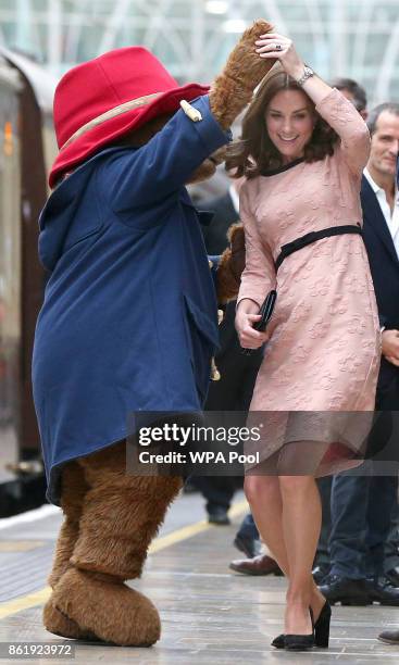 Catherine, Duchess of Cambridge dances with Paddington bear on platform 1 at Paddington Station as she meets the cast and crew from the forthcoming...