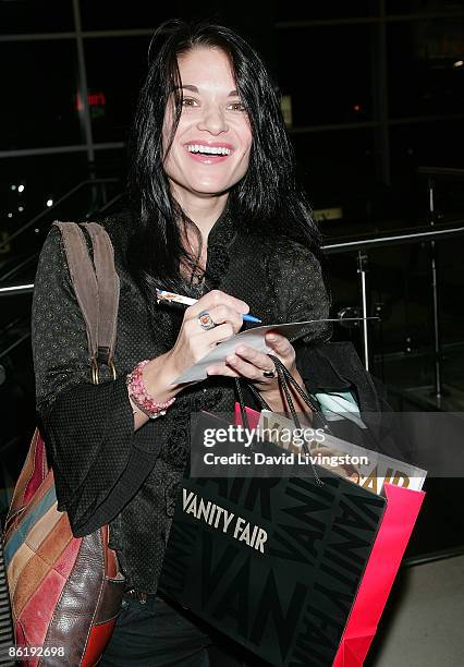 An audience member fills out a screening feedback form while holding a Vanity Fair gift bad at Film Independent's preview screening of 'Adoration' at...