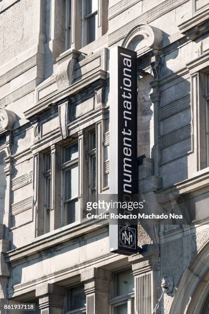 National monument signboard on a heritage building, vertical metal blackboard with white letters on a historic building. Old Montreal is a Unesco...