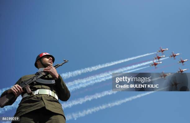 Turkish air force patrollers fly by as a Turkish soldier stands guard during the ceremony celebrating the 94th anniversary of Anzac Day in Canakkale...