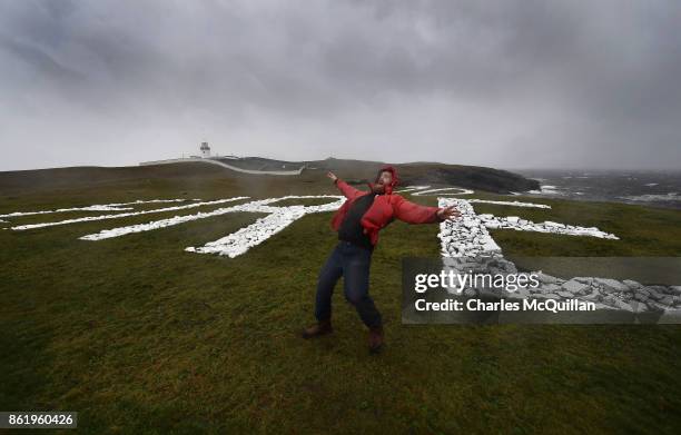 Al Mennie struggles against the wind at St. John's Point lighthouse where the word Eire is spelt out on white chalk for passing aeroplanes during...